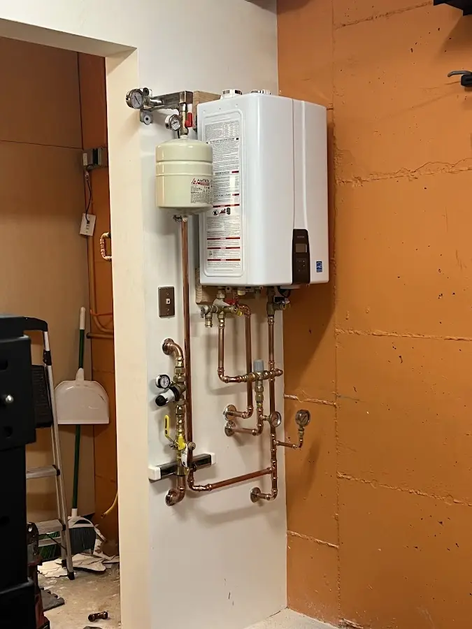 Plumbing technician inspecting water heater connections in Springfield